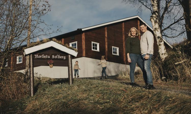 Bilde av familien foran innkjørselen til gården Nordstu Solberg. Fotograf: Stine Aasløkk